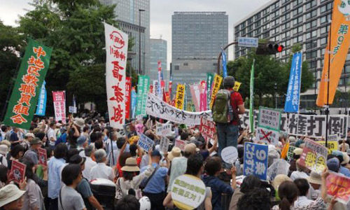 日本人敲锣打鼓抗议安倍决定行使集体自卫权。与一个月前相比，抗议人群中少了白发苍苍的老人，多了大学生一样的年轻人。