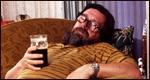 A man sitting on the sofa with a pint of beer