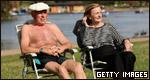 A retired couple sitting by a river