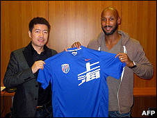 Chelsea striker Nicolas Anelka holding a Jersey of the Shenhua club with Shenhua club's investor, Zhujun, in Paris