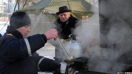 A social worker gives out tea to a man
