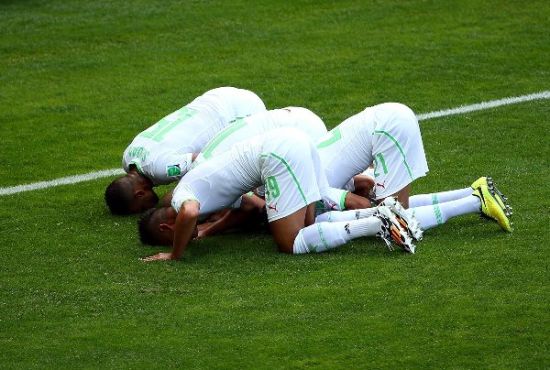 Algerian players kiss the ground after taking a lead over Belgium