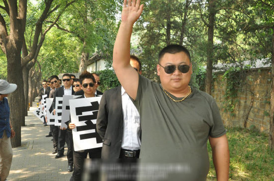 一戴着金项链、金戒指、金手表的土豪男站在豪车旁指挥人墙 一戴着金项链、金戒指、金手表的土豪男站在豪车旁指挥人墙
