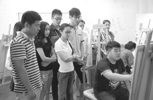 于腾(右前)在给高中部学生做绘画示范。　记者 王光营 摄