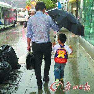 华人父亲只为孩子打伞自己淋湿