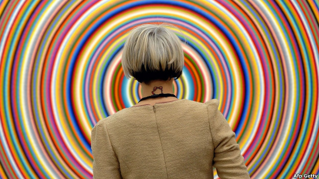 A woman checks a piece of artwork at an exhibition