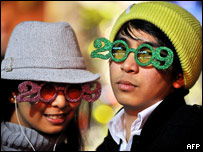 A couple wearing glasses shaped like the number 2009