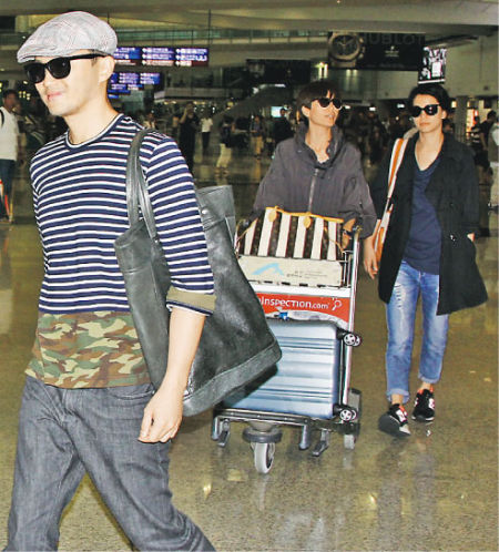 张智霖（左）与太太袁咏仪（右）昨天（9月30日）从上海返回香港，还有伍咏薇（中）推着行李，众人一起戴着墨镜出闸。