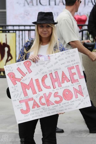 图文:歌迷举着写着迈克尔-杰克逊的牌子在等待