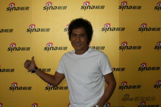 图文:齐秦做客聊天-新浪背景墙前留影