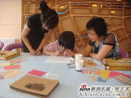 图为小女孩在指导下画油画