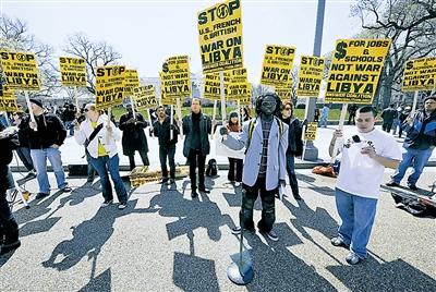 3 26, in the U.S. capital Washington, the White House, protesters holding signs to protest U.S. involvement in military action against Libya.