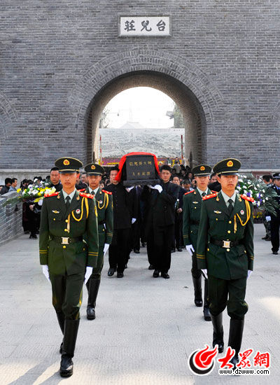 在四名武警战士的引领下走向城门外为无名英雄安葬。（高启民 摄）