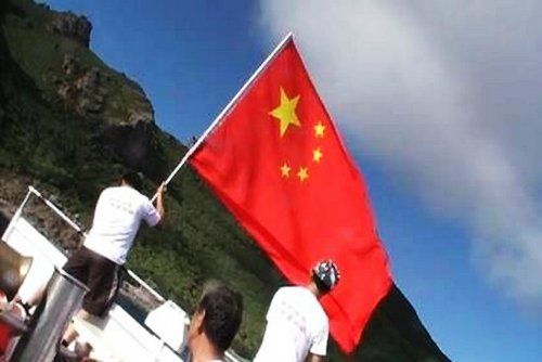 资料图：台湾保钓者在钓鱼岛近岸挥舞中国国旗