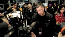 出事飞机上的乘客在机场讲述飞机迫降的过程。新华社发