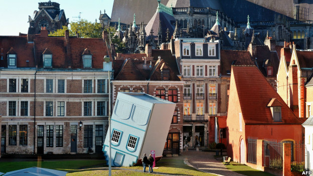 People watch an installation of an upside-down house in Lille. 
