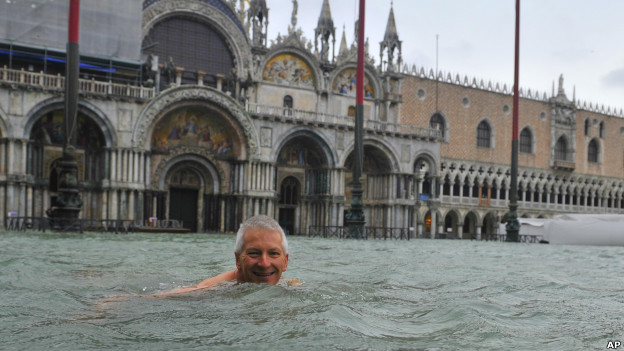 A man swims in Venice in a flooded St Mark's Square.