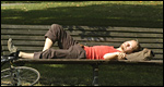 A boy sleeping on a bench