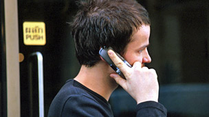 A man in the street using a mobile phone