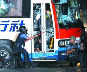 菲律宾警察试图打开被劫大巴车门。昨日，一辆载有22名香港游客的大巴在马尼拉被劫持，劫持者是一名被解职的菲律宾警察。