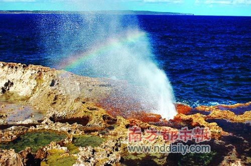 Water lapped the shore rocks, the air to form a small rainbow.