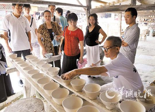 游客在景德镇陶瓷历史博览区观看老艺人手工制瓷