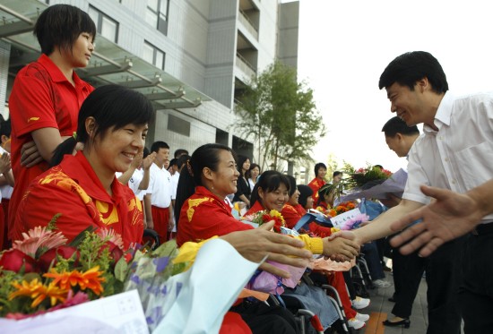 日,中国女子轮椅篮球队球员付永青(前左)和队友在送别仪式上接受鲜花