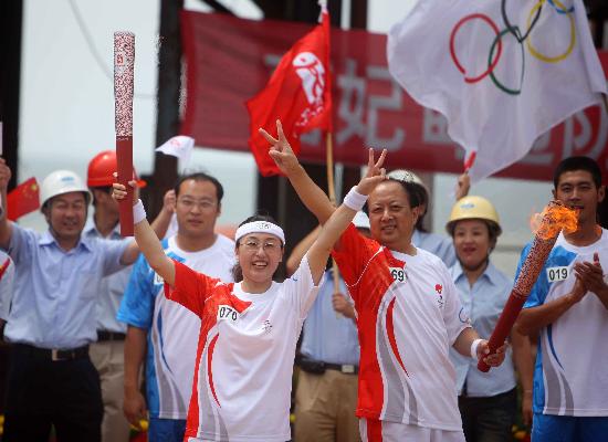 图文-奥运圣火在唐山传递 火炬交接时共同展示火炬