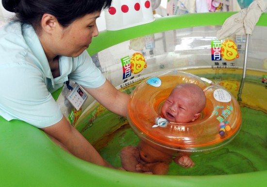 图文-新生宝宝游泳练习 护士将婴儿放入游泳池