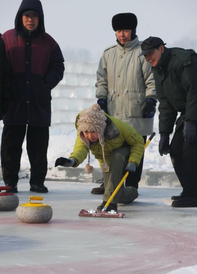 图文-冰天雪地玩冰壶 一名市民小心投掷冰壶_