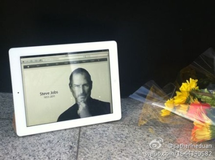 一位员工从苹果总部一号楼出来，在纪念的地方放下一个白色iPad，这应该是乔布斯最喜欢的相框。