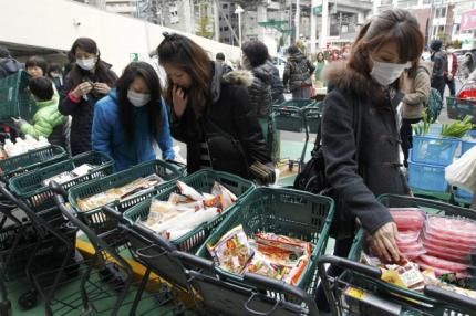 图为日本仙台县居民在临时开业的超市内抢购食品