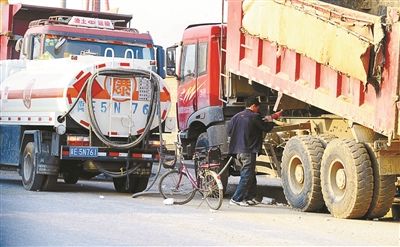 在这些货车中间,四五辆写着"爆"字的油罐车缓慢地在其中穿梭.