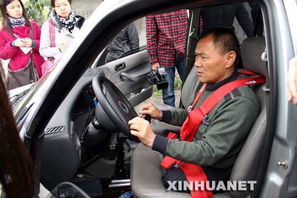 4月1日,下肢殘疾的曹前明坐在專用考試車駕駛座上,準備進行實際路況