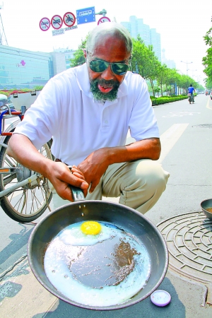 记者将鸡蛋打入铁锅中,放在马路地表上,30多分钟的时间,鸡蛋竟然煎熟