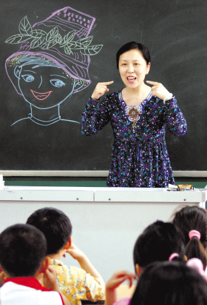 中原区外国语小学二六班的"微笑课"上,杜老师在演示笑的技巧.