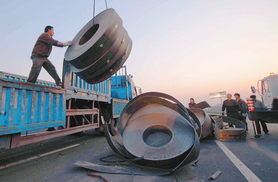 数吨钢卷滚落 砸扁过路轿车