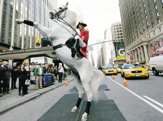 10月14日,美国纽约,身穿古代骑士装的表演者走上街头,为马术表演做