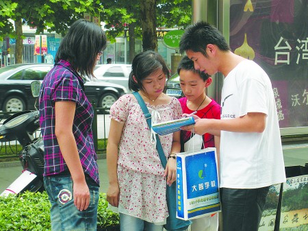 彭伟(右)正在街上发传单本报记者徐洁摄