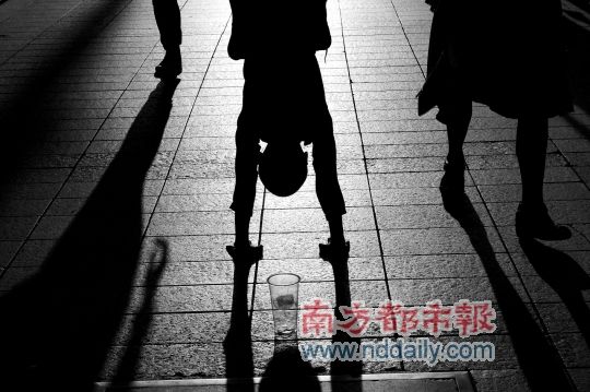 一个十岁左右的男孩日前在东门倒立乞讨.
