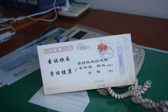 李华波逃跑前没有处理办公室，一张明信片孤零零的留在桌上。