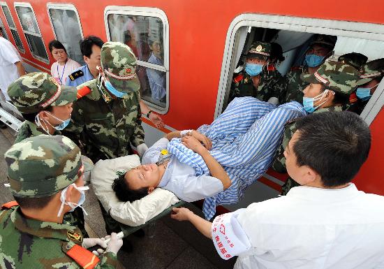 图文:武警和医务人员将伤员从车窗抬出列车