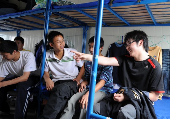 图文:夹缝男孩廖波在学校寝室里与同学聊天