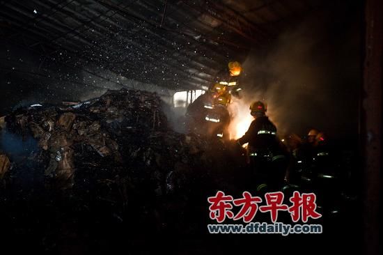 昨日，消防员察看火场。失火仓库内堆满纸板箱，被全部付之一炬。早报记者 杨一 图