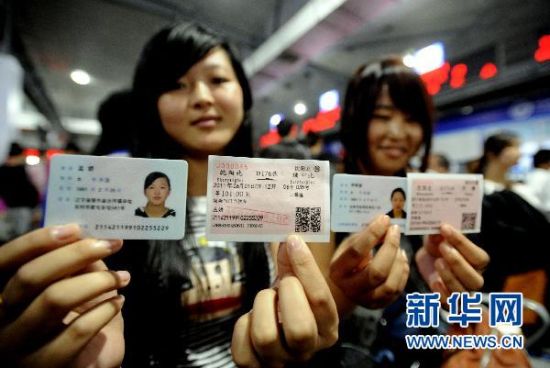 6月1日,两名旅客在沈阳北站展示自己的身份证和动车车票