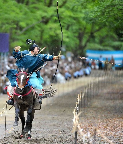 日本京都举行传统骑射仪式参加者骑马射击图