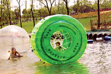 游客在玩水上悠波球