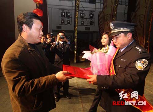 娄底市副市长余明庭为获得娄底市首届"执法为民好警察"谢劭颁奖.
