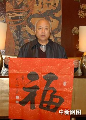图为柳国庆在浦东展示其书赠中外金融界人士的福字新作.摄影:魏池