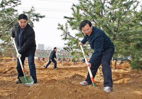 图为省委书记强卫(右),省委常委,市委书记王建军(左)正在参加植树